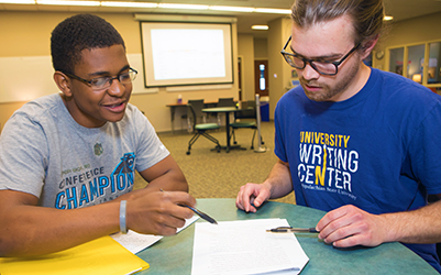 An African American student in a session with a white man wearing a UWC T-shirt